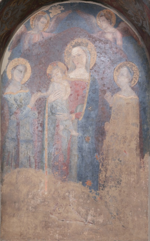 Detached fresco from a street shrine, displayed in a round-arched niche. On a blue ground, the crowned Virgin stands at the centre in a blue mantle scattered with gold stars over a red dress, holding the Christ Child on her right arm. The Child holds a scroll and turns towards Saint Catherine of Alexandria on the left, who wears a pale blue gown and extends her hand to receive the ring. On the right, a second haloed female saint in a golden gown raises her hand; below her, the kneeling donor, probably a knight, is almost entirely lost. Two winged angels hover above the Virgin. The vault of the niche is painted with dark red foliage and a lozenge at the top. In the right embrasure stands Saint Lucy; in the left, only the halo of another saint survives. The lower part of the fresco is heavily abraded.