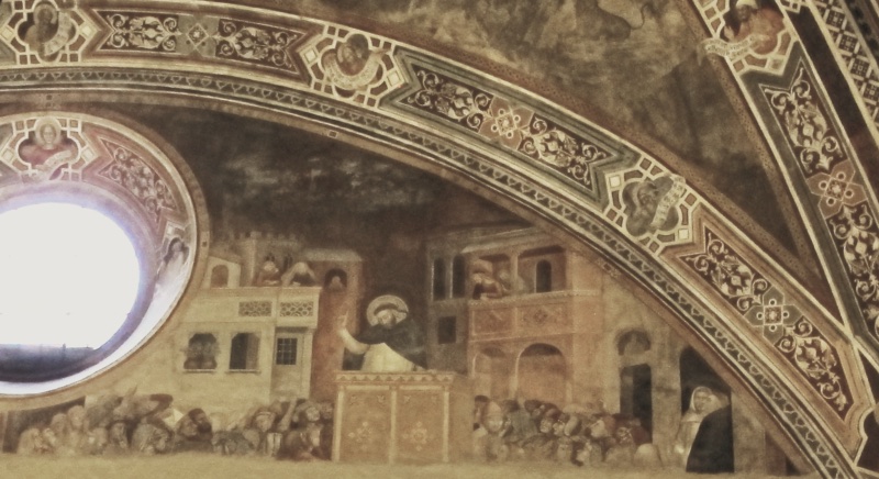 Fresco by Andrea di Bonaiuto showing St Peter Martyr preaching from a wooden pulpit to a dense crowd in a city square, with listeners leaning from the balconies of surrounding palazzi, from the Scenes of the Life of St Peter Martyr, upper entrance wall of the Spanish Chapel, Santa Maria Novella, Florence, 1366-67
