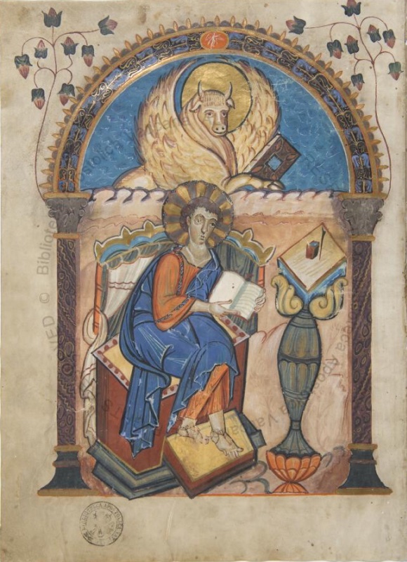 Full-page miniature from the Codex Aureus of Lorsch: Saint Luke seated on a cushioned throne holding an open book, a lectern beside him, while his symbol, a gold-haloed winged ox clasping a codex, hovers in the blue lunette of an ornamented arch