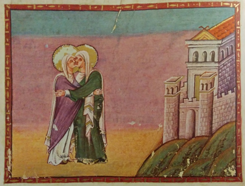 Medieval miniature in a red frame with gold ornament, above red lettering and a large gold initial: under a sky shading from turquoise to violet-rose above golden ground, two haloed women in white veils embrace cheek to cheek at the left, one in a violet mantle, the other in a green mantle with a gold-striped white shawl; at the right a walled city with towers, an arched gate and a red-roofed building stands on a green hill