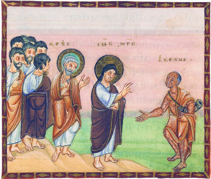 Medieval miniature in a dark red frame with gold ornament, against a pale pink sky above green ground: at left a group of apostles, the foremost white-haired and haloed in gold with hands raised; in the centre Christ, haloed in gold and wearing a purple mantle, raises his hand in blessing; at right a bald, half-crouching man covered with dark spots, a white horn hanging at his side, stretches out his hand towards Christ