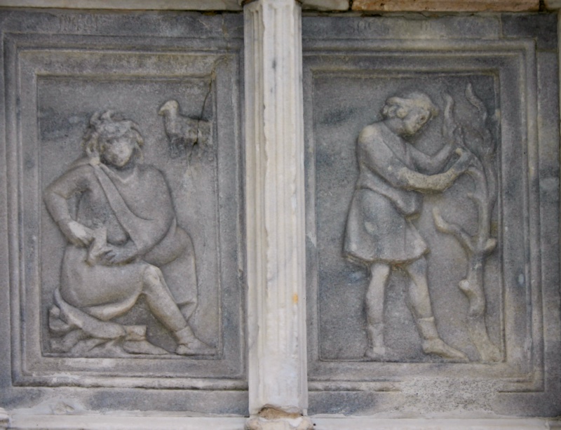 Fontana Maggiore, Perugia: March relief, a seated peasant pulling a thorn from his foot beneath Aries, beside a man pruning a vine