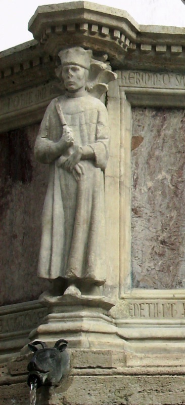 Fontana Maggiore, Perugia: statue of Ermanno da Sassoferrato, capitano del popolo of Perugia, on the Fontana Maggiore — a magistrate in a lobed cap and long gown holding a baton, above a bronze ram-head spout, 1278