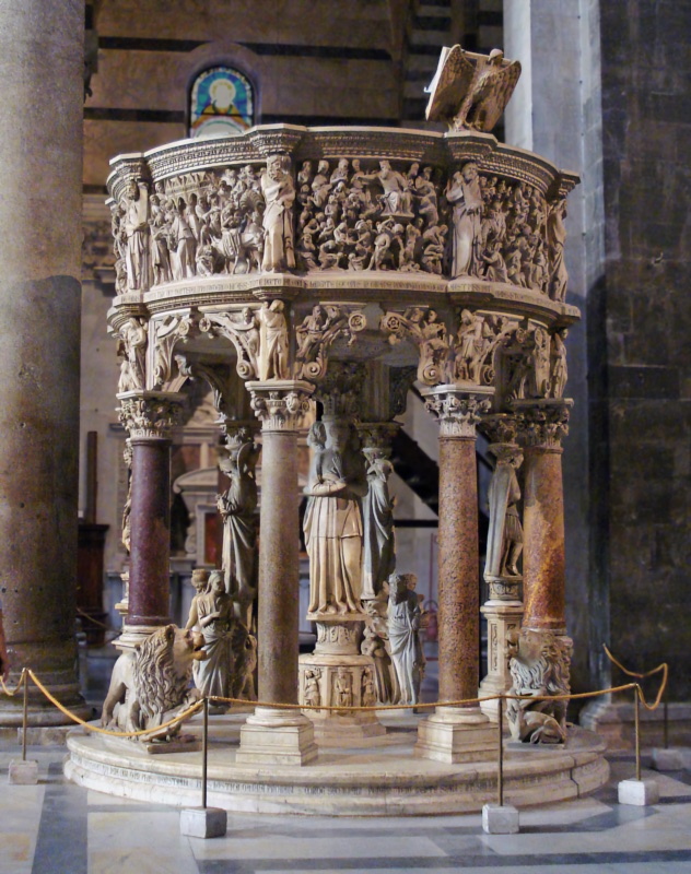 Circular marble pulpit on porphyry columns and carved figure-supports, its curved parapet densely carved with crowded relief scenes, an eagle lectern projecting at the upper right.