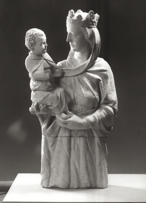 Marble sculpture of a crowned, veiled Virgin holding the Christ Child on her left arm; mother and child turn their heads toward one another, their faces meeting at close range, the drapery falling in long diagonal folds. Photographed in studio light against a dark ground.