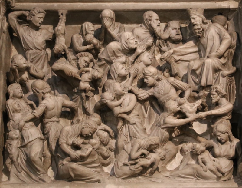 Marble relief packed edge to edge with violently contorted figures: a crowned man leans forward from a throne at the upper right; young soldiers in short tunics raise their arms to strike and wrench infants from women's grasp; mothers clutch living children or bend double over dead ones; small nude bodies lie heaped along the lower edge; at the upper centre one veiled woman has drawn her hands across her eyes.
