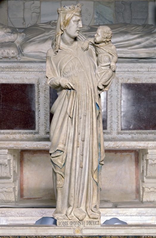 Marble statue of a crowned and veiled Virgin standing frontally, the Christ Child on her left arm turning his head back toward her and raising a hand to her shoulder; her mantle falls in long vertical folds gathered by a knotted cord, with traces of blue on the lining and gold on the hem and veil. The base is inscribed in Gothic letters. Behind rises a carved tomb with a recumbent effigy.