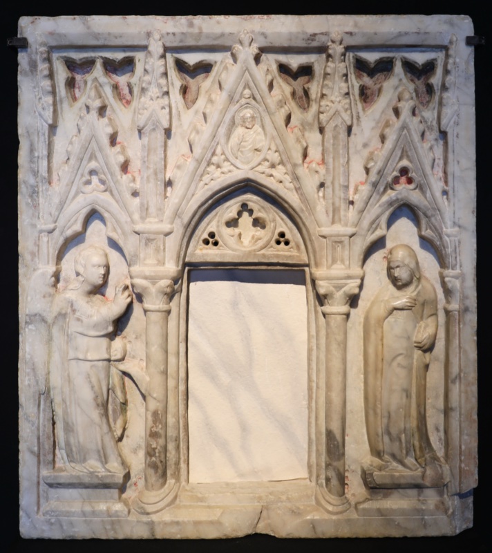 Marble Sacrament tabernacle attributed to Giovanni di Agostino, c. 1331–32: the archangel Gabriel and the Virgin Annunciate flank a central door opening beneath crocketed Gothic gables; from Sant'Eugenio a Monistero, now in the chapel of Palazzo Chigi Saracini, Siena
