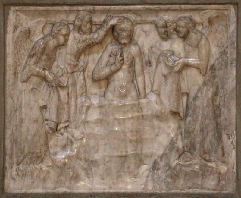 Marble relief attributed to Giovanni di Agostino, c. 1332, on the baptismal font of the Pieve di Santa Maria, Arezzo: Christ stands waist-deep in the smooth mound of the Jordan, a carved drop of water running down his chest, while the Baptist lays a hand flat on his head from the left bank and three bowing angels hold his garments at either side.