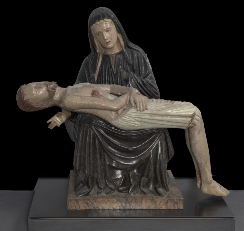 Polychrome wooden Pietà: the Virgin, seated in a dark hooded mantle with a pale, still face, holds the rigid pale body of the dead Christ horizontally across her lap. His bearded head falls sharply backward over her knee with mouth open, one arm dangling, and a long white cloth in sharp parallel folds wraps his hips and thighs. Red wounds mark the chest and limbs