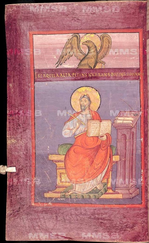 Ottonian manuscript page on purple-stained parchment. In an upper register on a pale mauve ground, a haloed eagle with spread wings and head in profile perches above a book. Below it, a purple band carries one line of gold capitals: EST AQUILA ALTA PETENS NARRANS DIVINA IOHANNES. In the main field, on a blue-violet ground, the haloed evangelist John, elderly with long hair and a grey beard, sits frontally on a gold block throne with a green cushion. He wears a white tunic and a bright red mantle and holds an open book filled with script in one hand, writing in it with a quill held in the other. His feet rest on a green footstool. At right stands a tall mauve pedestal lectern with an arched niche, bearing scrolls and an inkwell. A small parchment tab projects from the left edge.