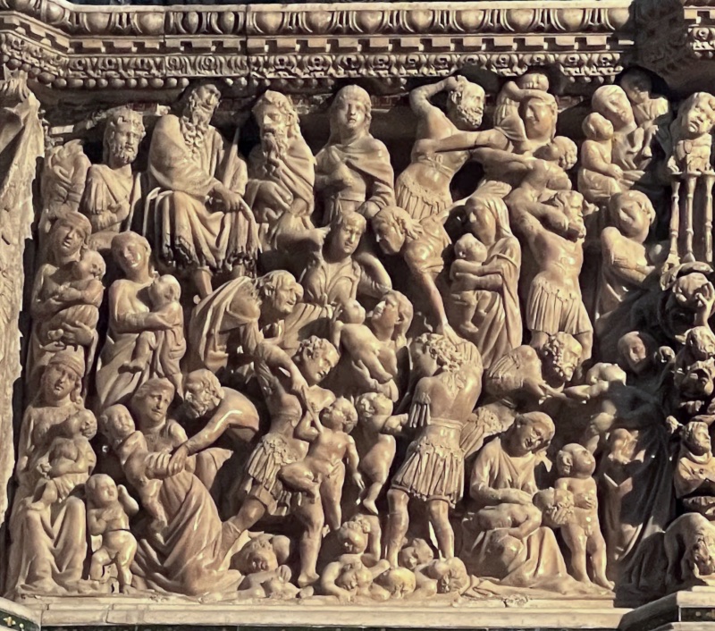 Marble relief packed edge to edge with struggling figures: a crowned man sits enthroned at the upper left; below and to the right, young soldiers in short tunics raise their arms and seize infants; veiled women crouch and clutch children at the left; small nude bodies lie heaped along the bottom of the panel.