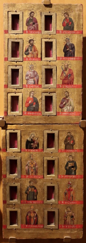 Two gold-ground wooden panels one above the other, each divided into four rows. In each row two small relic recesses, framed in tooled gilt metal and lined with red fabric behind glass, alternate with two half-length haloed saints standing above red name bands in gold Gothic letters. Upper panel: James and Philip; Mark and Andrew; Peter, with keys, and Paul, with sword and book; Simon and Bartholomew. Lower panel: the Virgin in a white veil holding the Christ Child, and Saint Francis in a brown habit with a red cross and book; the bishop Saint Nicholas blessing, and the deacon Saint Stephen with palm and book; the deacon Saint Lawrence, and the bishop Saint Blaise with crozier; the bishop Saint Apollinaris with crozier, and the deacon Saint Vincent with palm. The haloes are decorated with punched dots and stars, and the gold surface shows fine cracking