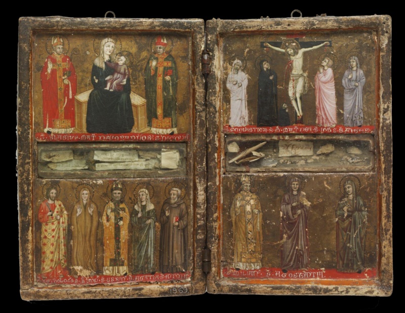 Left wing of a small painted reliquary diptych with a worn, raised wooden frame. Above, on a darkened gold ground, the Virgin in a white veil and dark green mantle sits on a block throne holding the Christ Child in pink, between two bishop saints: Blaise in red and Nicholas in green. A red band below names them in white letters. In the middle a glazed recess holds relics wrapped in small paper labels written in ink. Below stand five saints over a red inscribed band: Bartholomew with a knife, Mary Magdalene covered in her long hair, the bishop Urban, Agatha in a white veil, and Anthony Abbot in a brown habit with a red book; Right wing of a small painted reliquary diptych with a worn, raised wooden frame. Above, on a darkened gold ground, Christ hangs on the cross with blood running from his wounds; a tiny kneeling monk in a black habit embraces the foot of the cross. Beside the cross stand the Virgin in black and Saint John in pink looking up, flanked by two female saints in white and pale blue-grey robes. A red band names them in white letters. In the middle a glazed recess holds bone fragments and folded paper relic labels. Below stand a bishop saint in a golden chasuble with crozier and two female saints in maroon and green, over a red band naming Saint Emilian and Saint Constantia